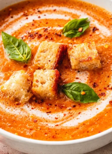 A comforting bowl of creamy homemade tomato soup with a side of crusty bread.