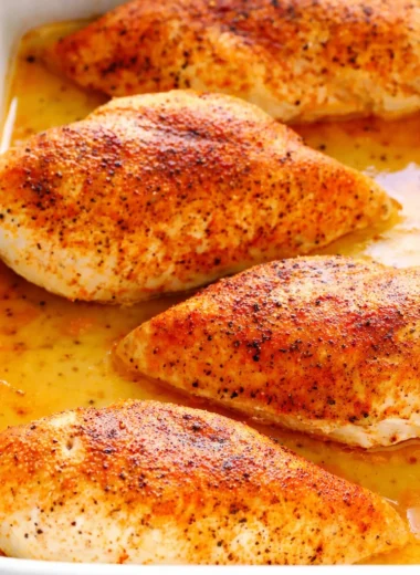 Juicy baked chicken breast garnished with herbs, perfect dinner recipe.