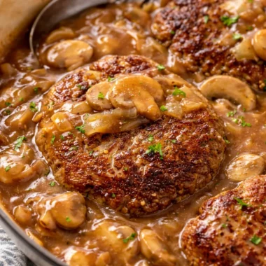 Juicy Salisbury steak with mushrooms and rich gravy on a plate.