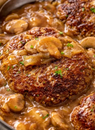Juicy Salisbury steak with mushrooms and rich gravy on a plate.