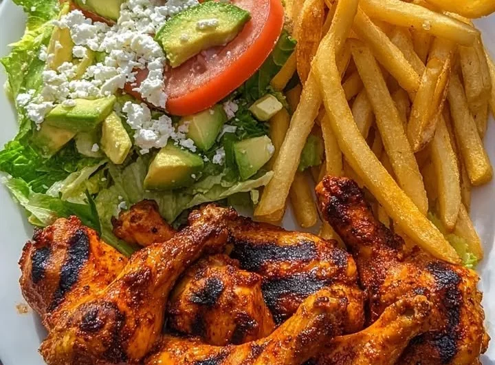Crispy grilled chicken drumsticks served with fries and avocado salad