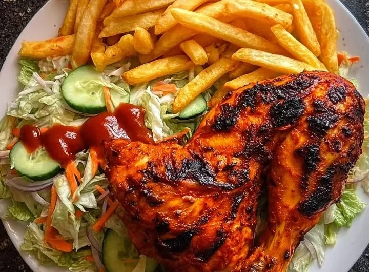 Delicious flame-grilled chicken leg quarters served with fries and salad