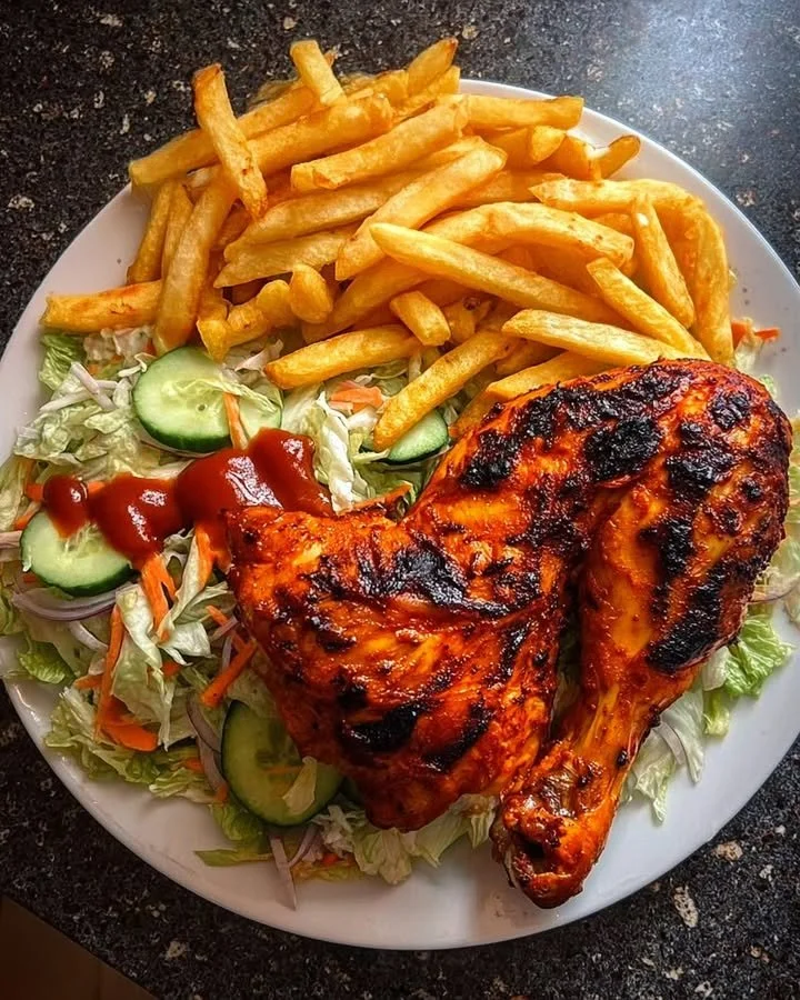 Delicious flame-grilled chicken leg quarters served with fries and salad