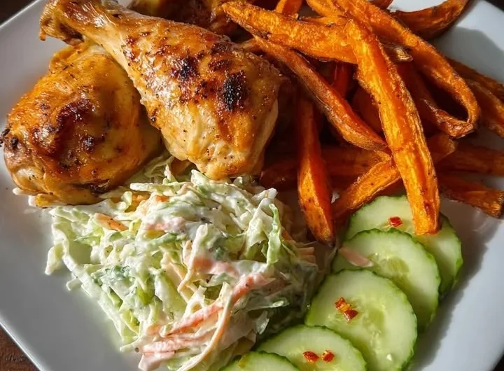 Roasted chicken drumsticks served with sweet potato fries and creamy coleslaw.