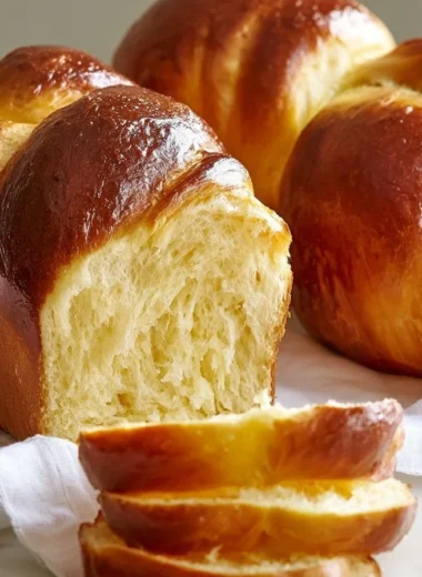 Freshly baked buttery French brioche loaf on a wooden surface