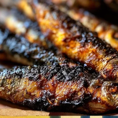 Plate of crispy grilled sardines garnished with citrus slices