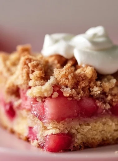Slice of Crispy Rhubarb Streusel Cake with vibrant rhubarb and crunchy topping