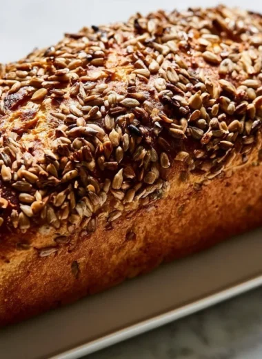 Crispy sunflower seed bread slices on a wooden cutting board.