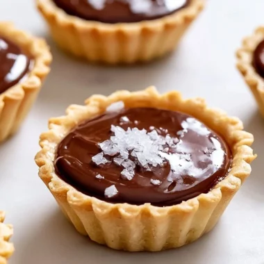 Decadent French chocolate tartlets garnished with fresh fruit and whipped cream