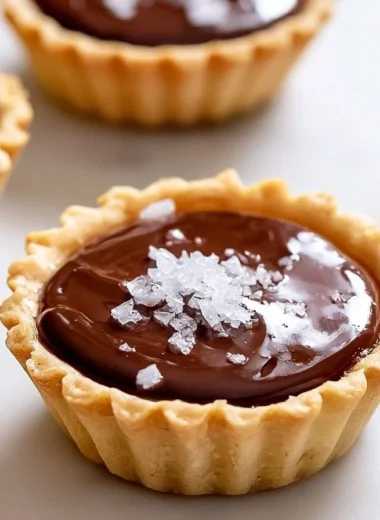 Decadent French chocolate tartlets garnished with fresh fruit and whipped cream