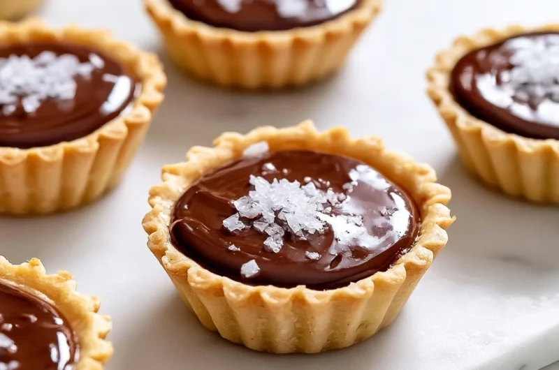 Decadent French chocolate tartlets garnished with fresh fruit and whipped cream