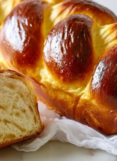 Freshly baked golden brioche bread loaf on a wooden cutting board